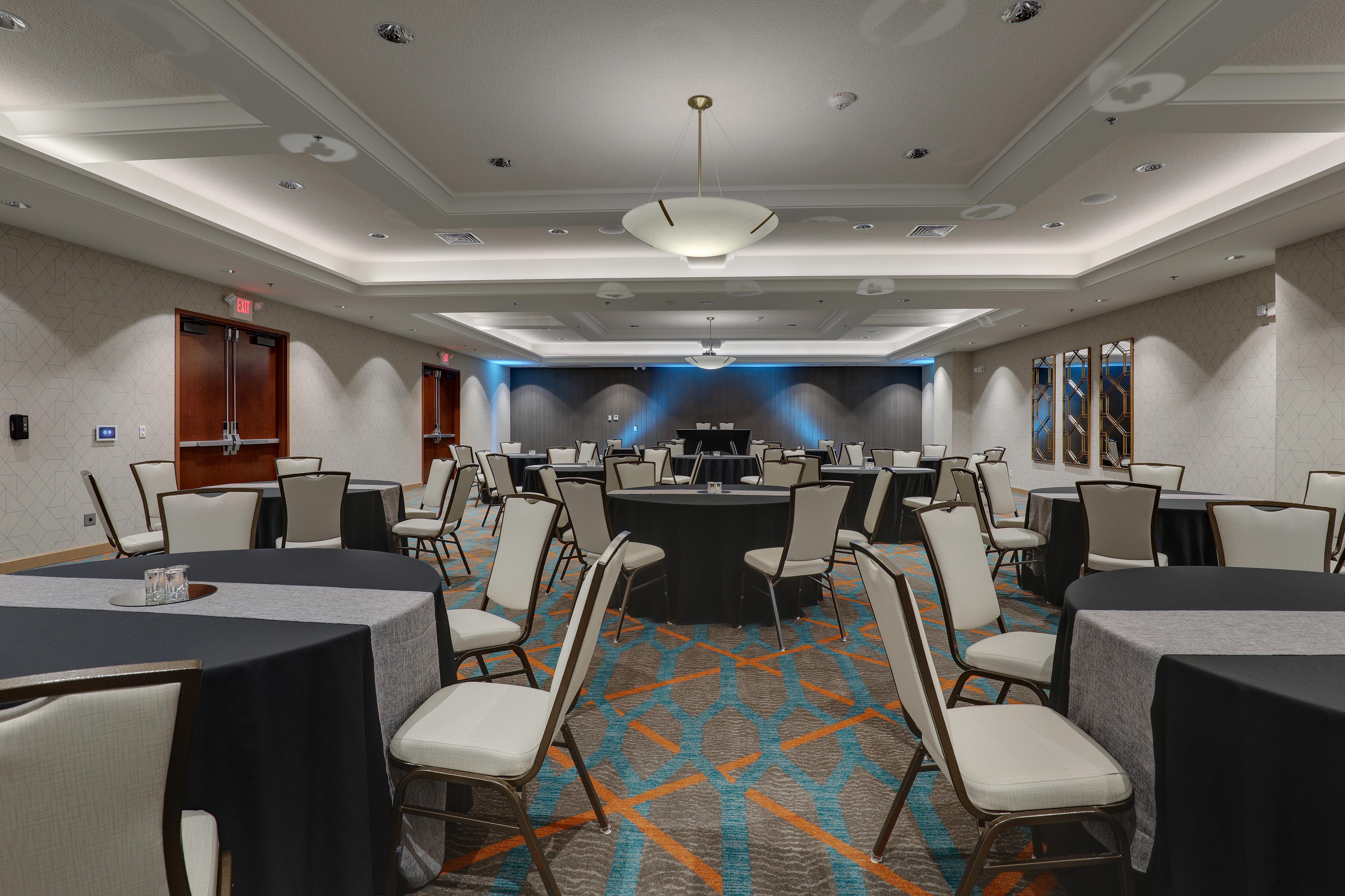 Large meeting space, set up with round tables throughout